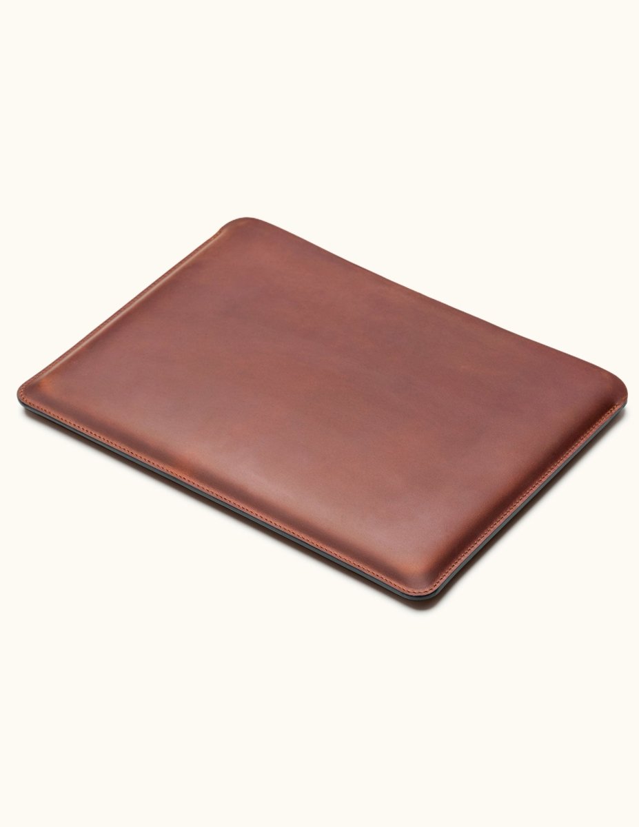 Angled view of vintage brown full-grain leather MacBook sleeve, slim and minimalist desig