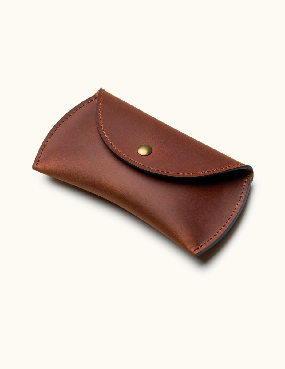 Brown leather travel case for Apple Magic Mouse with snap button closure, angled view