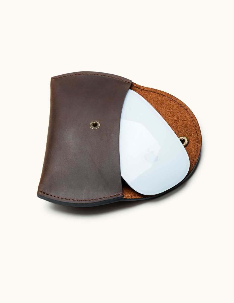 Dark brown full-grain leather sleeve with Apple Magic Mouse partially inserted, showing fit and interior textur