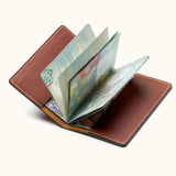 Open brown leather passport holder showing passport pages – minimalist travel wallet for frequent flyers