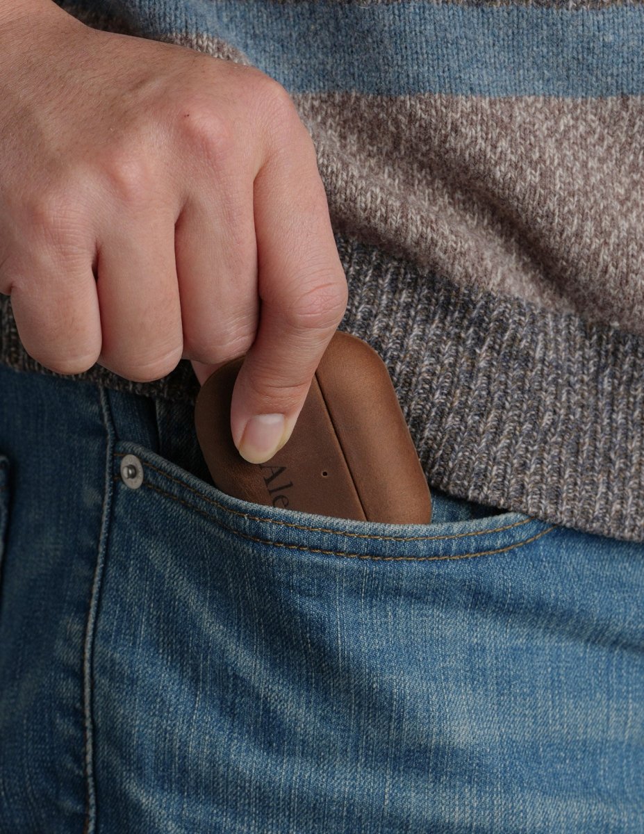 Close up of a man taking a custom brown crazy horse leather AirPods Pro 3 case out of his blue jeans front pocket. Everyday carry tech accessory.