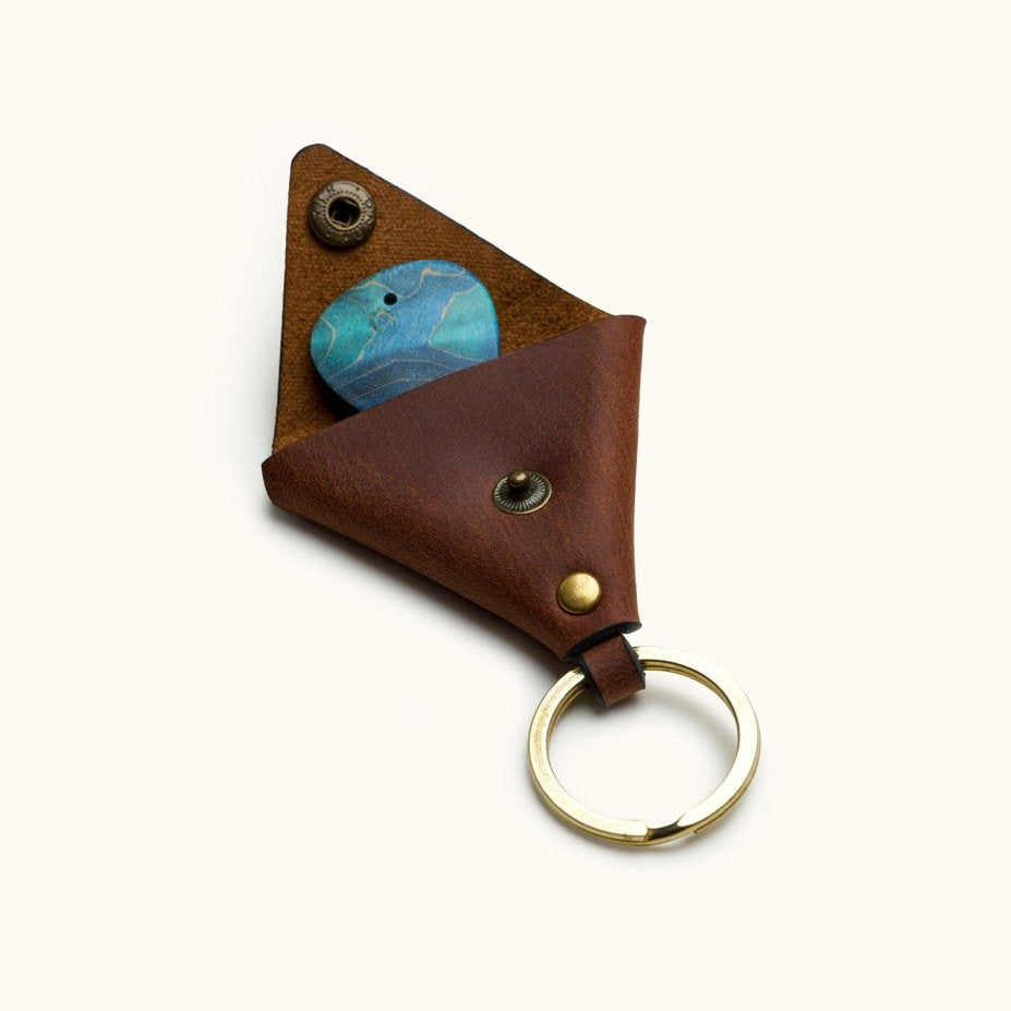 Open triangular leather guitar pick keychain holder with brass snap and visible blue pick inside