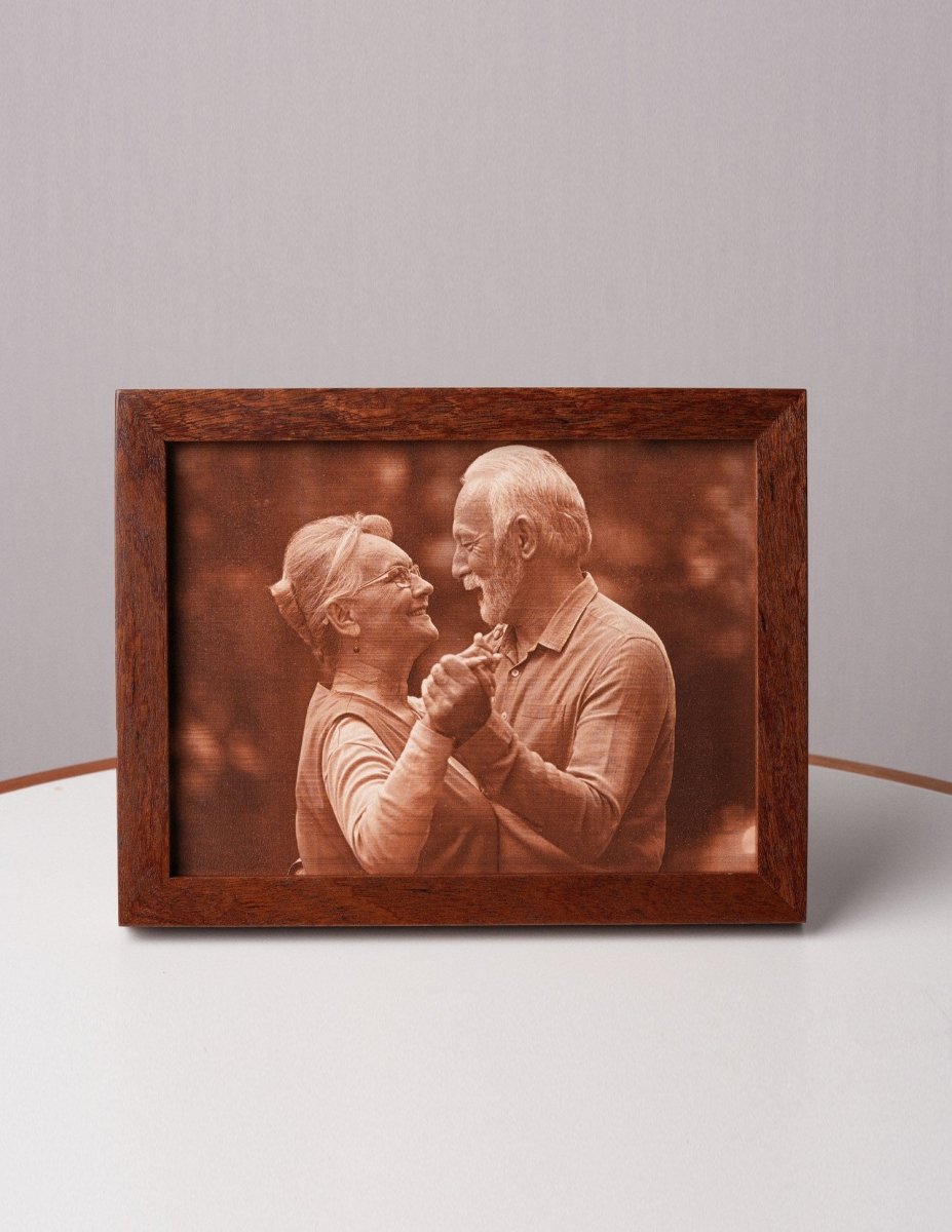 Laser-engraved leather photo of an elderly couple dancing, framed in wood and displayed on a table — a heartfelt anniversary gift for parents or a 3rd wedding anniversary keepsake
