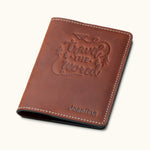 Vintage brown leather passport cover with 'Travel the World' embossed design and personalized name Josefina