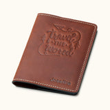 Vintage brown leather passport cover with 'Travel the World' embossed design and personalized name Josefina