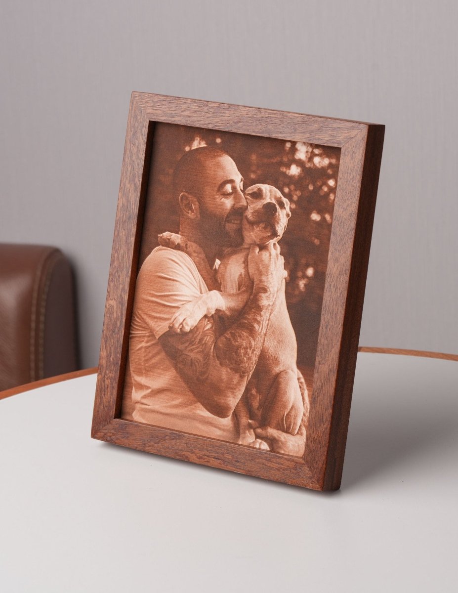 Side view of a custom laser-engraved leather photo showing a man embracing his dog, framed in wood — a perfect personalized gift for dog lovers or pet memorials