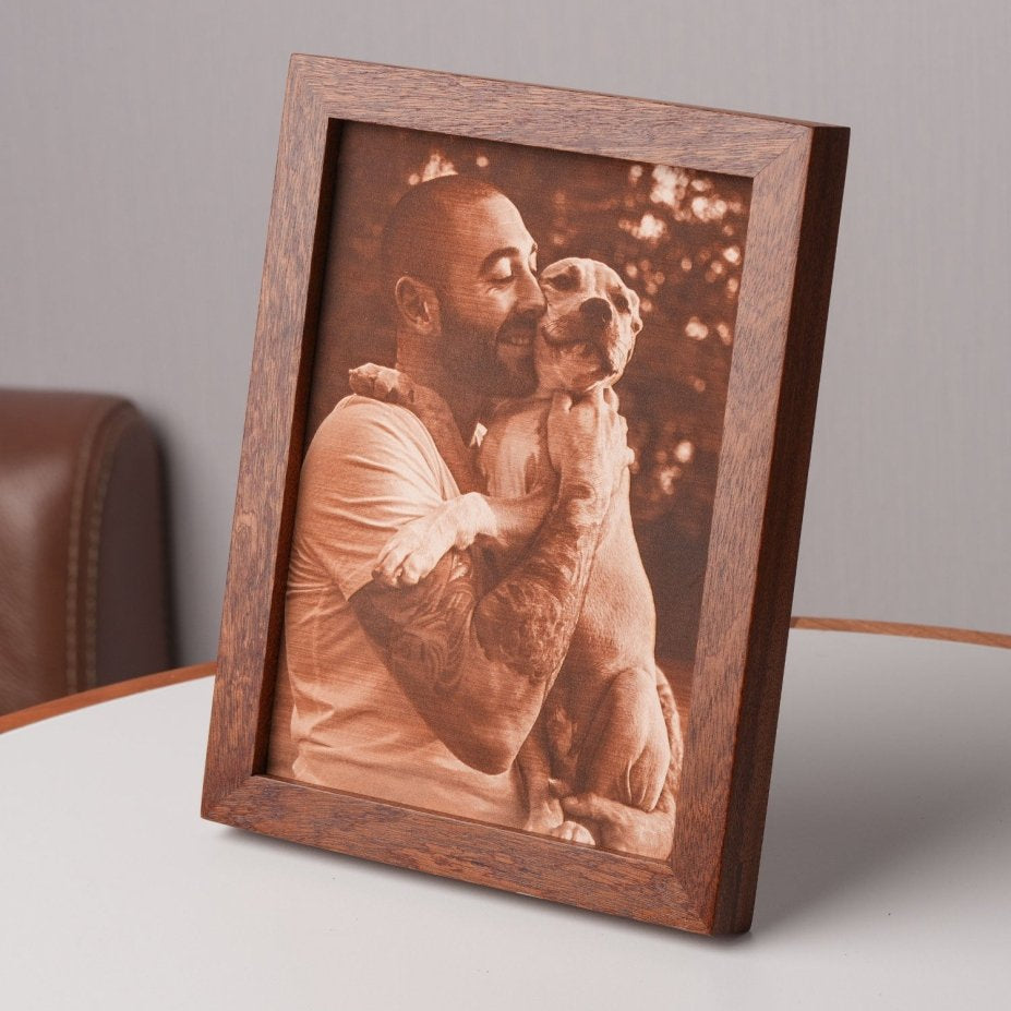 Side view of a custom laser-engraved leather photo showing a man embracing his dog, framed in wood — a perfect personalized gift for dog lovers or pet memorials