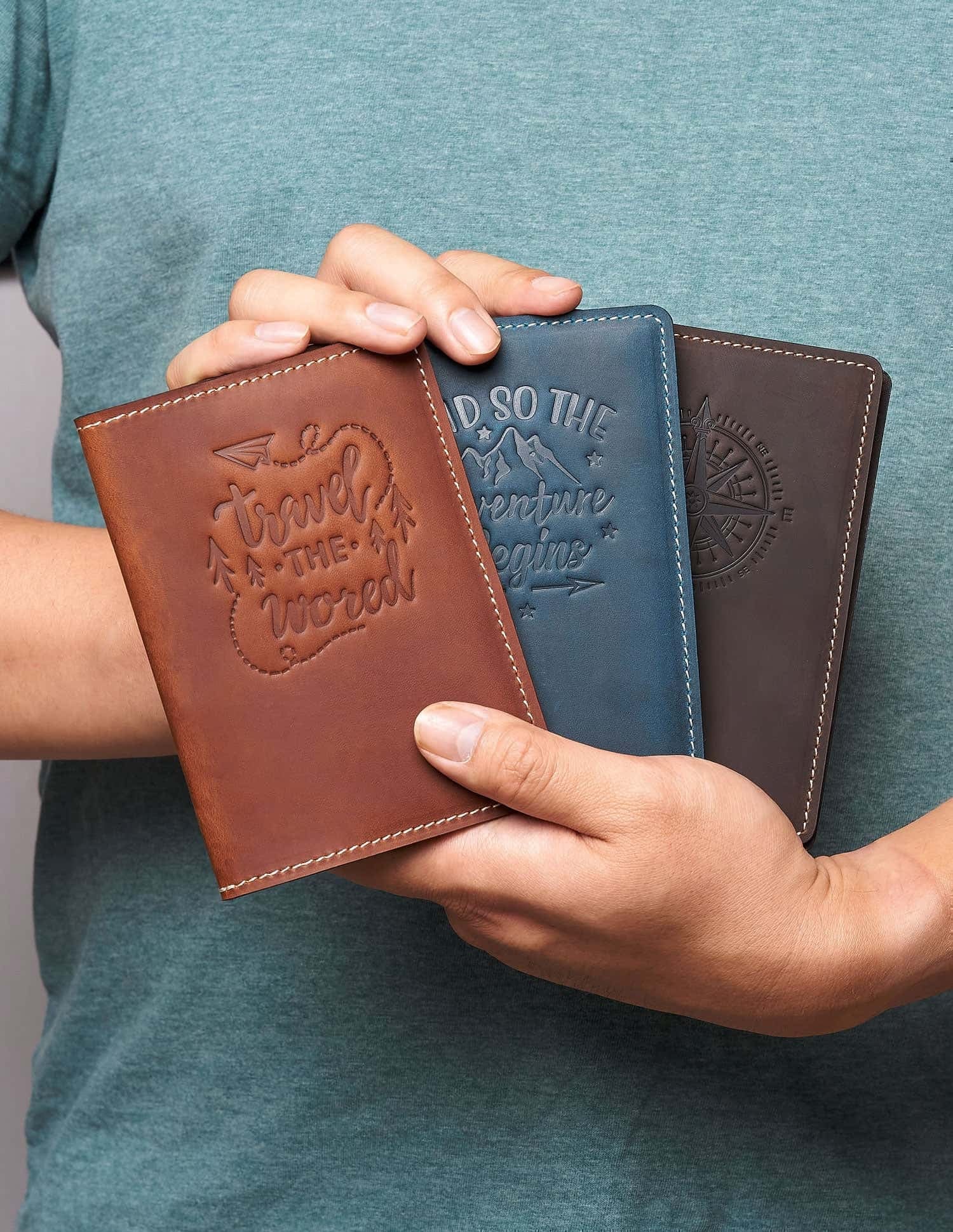Person holding three personalized leather passport covers in Vintage Brown, Navy, and Coffee – travel-ready and customizable gifts